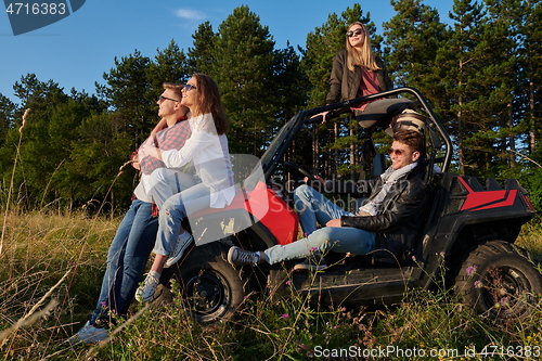 Image of group young happy people enjoying beautiful sunny day while driving a off road buggy car