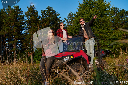 Image of group young happy people enjoying beautiful sunny day while driving a off road buggy car