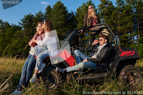 Image of group young happy people enjoying beautiful sunny day while driving a off road buggy car