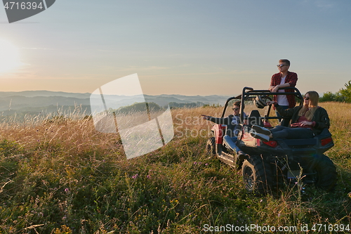 Image of group young happy people enjoying beautiful sunny day while driving a off road buggy car