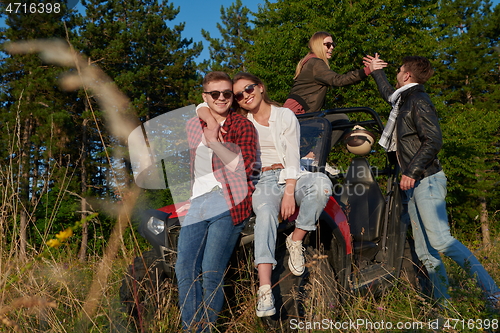 Image of group young happy people enjoying beautiful sunny day while driving a off road buggy car