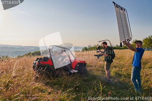 Image of cameraman recording a young couple enjoying a buggy car ride up a mountain