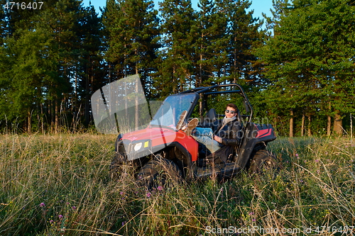 Image of man enjoying beautiful sunny day while driving a off road buggy car