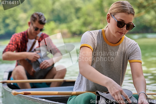 Image of friends are canoeing in a wild river