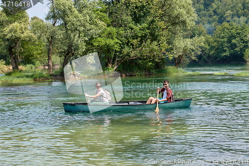 Image of friends are canoeing in a wild river