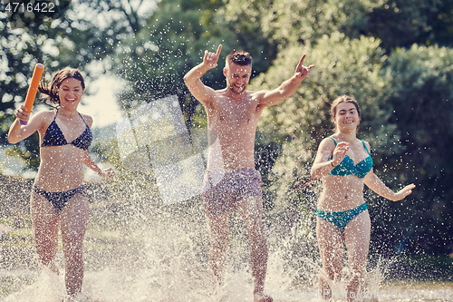 Image of group of happy friends having fun on river