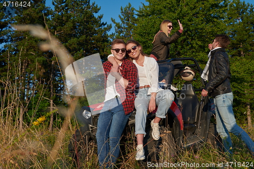 Image of group young happy people enjoying beautiful sunny day while driving a off road buggy car