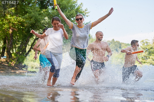 Image of group of happy friends having fun on river