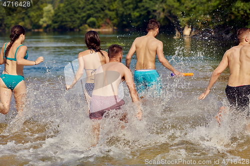 Image of group of happy friends having fun on river