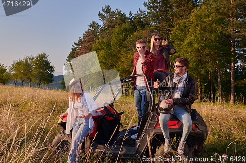 Image of group young happy people enjoying beautiful sunny day while driving a off road buggy car