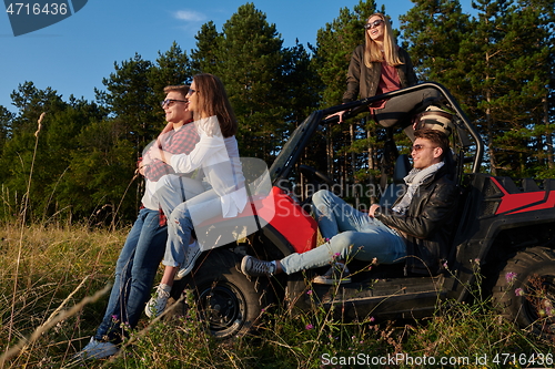 Image of group young happy people enjoying beautiful sunny day while driving a off road buggy car