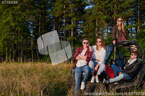 Image of group young happy people enjoying beautiful sunny day while driving a off road buggy car