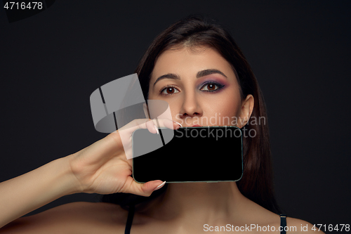 Image of Lie and another life in social media. Girl with make up only on half of her face. Playing pretend. Blank phone screen.