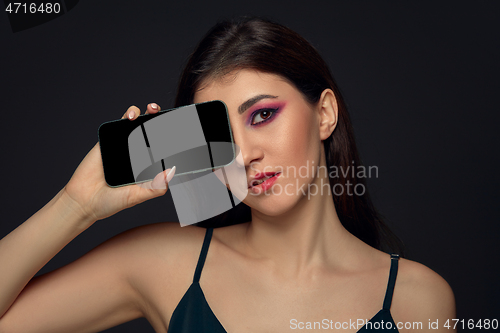 Image of Lie and another life in social media. Girl with make up only on half of her face. Playing pretend. Blank phone screen.