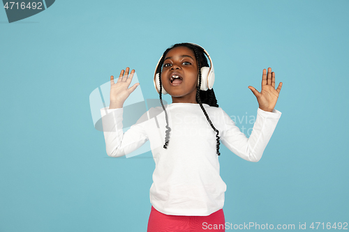 Image of Handsome african little girl portrait isolated on blue studio background with copyspace