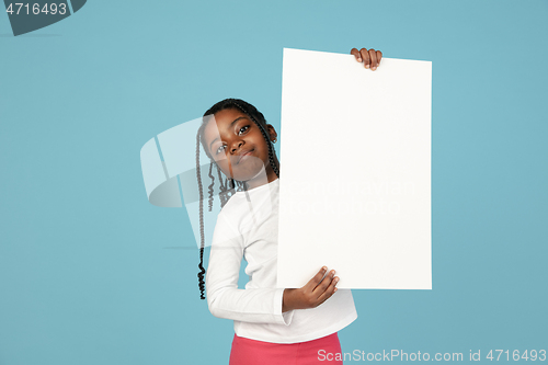 Image of Handsome african little girl portrait isolated on blue studio background with copyspace