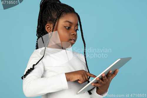 Image of Handsome african little girl portrait isolated on blue studio background with copyspace