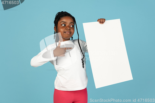 Image of Handsome african little girl portrait isolated on blue studio background with copyspace