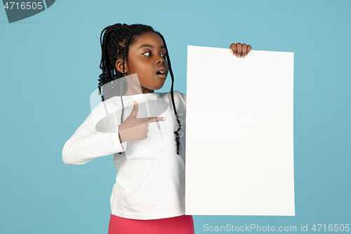 Image of Handsome african little girl portrait isolated on blue studio background with copyspace