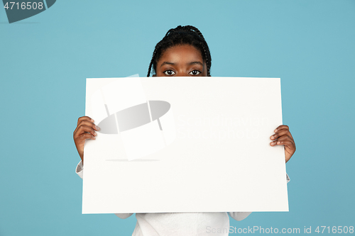 Image of Handsome african little girl portrait isolated on blue studio background with copyspace