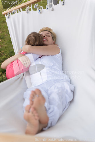 Image of mother and a little daughter relaxing in a hammock