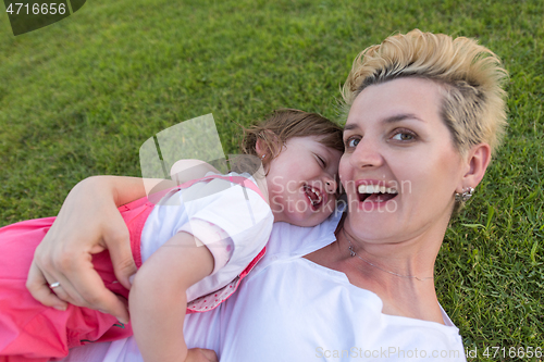 Image of mother and little daughter playing at backyard