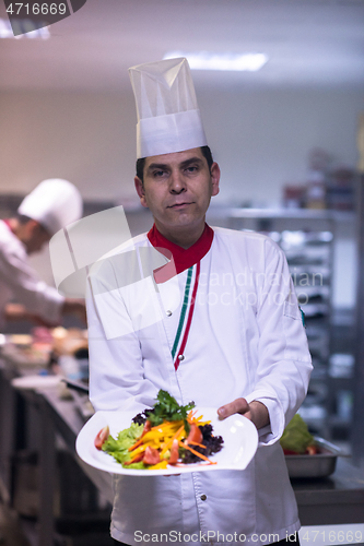 Image of Chef showing a plate of tasty meal