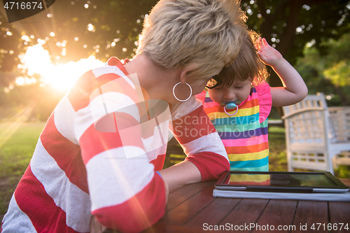 Image of mom and her little daughter using tablet computer