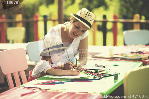 Image of mom and little daughter drawing a colorful pictures