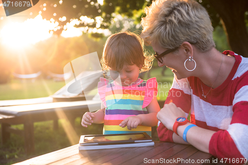 Image of mom and her little daughter using tablet computer