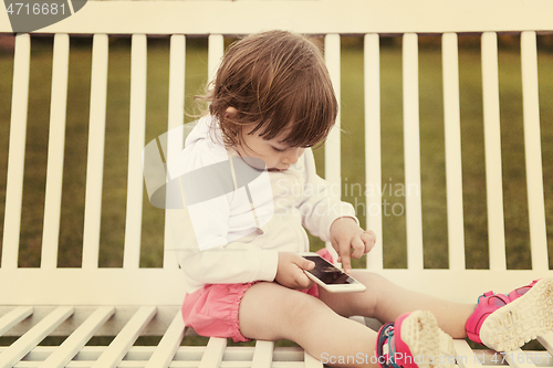 Image of little girl playing with mobile phone