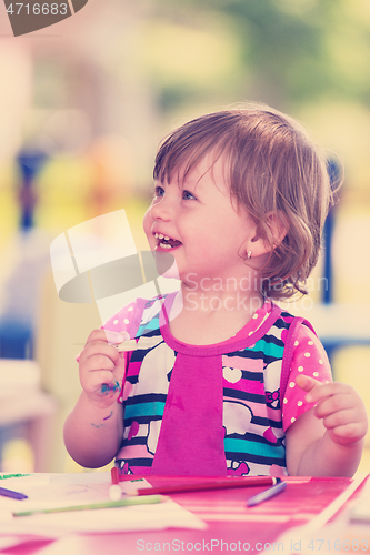 Image of little girl drawing a colorful pictures