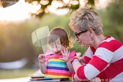 Image of mom and her little daughter using tablet computer