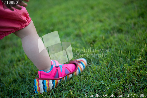 Image of little Girl wearing big shoes of her mother