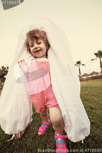 Image of mother and little daughter playing at backyard