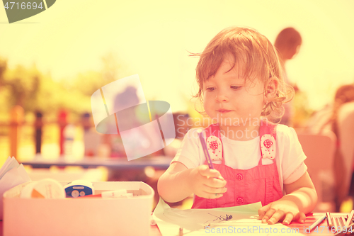 Image of little girl drawing a colorful pictures