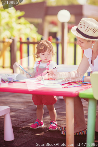 Image of mom and little daughter drawing a colorful pictures