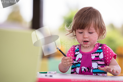 Image of little girl drawing a colorful pictures