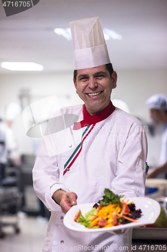 Image of Chef showing a plate of tasty meal