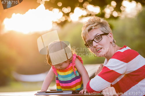 Image of mom and her little daughter using tablet computer