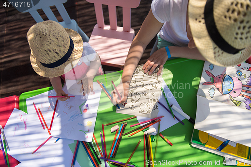 Image of mom and little daughter drawing a colorful pictures