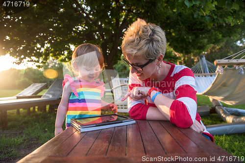 Image of mom and her little daughter using tablet computer