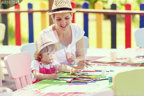 Image of mom and little daughter drawing a colorful pictures