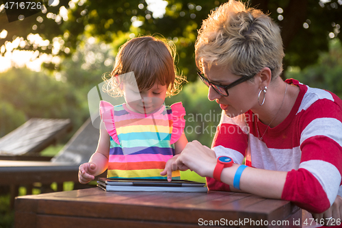 Image of mom and her little daughter using tablet computer