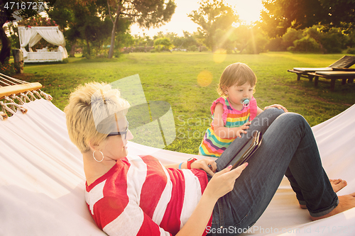 Image of mom and a little daughter relaxing in a hammock