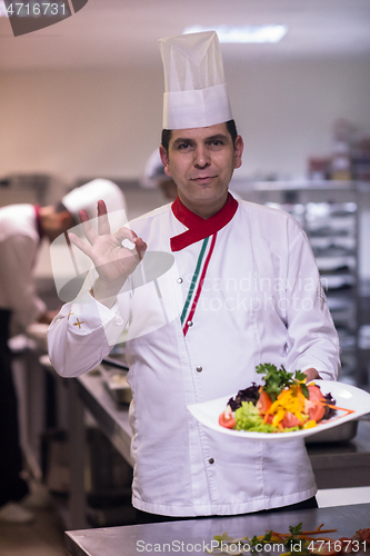 Image of Chef showing a plate of tasty meal