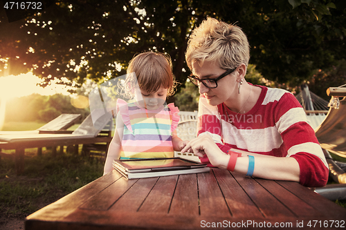 Image of mom and her little daughter using tablet computer