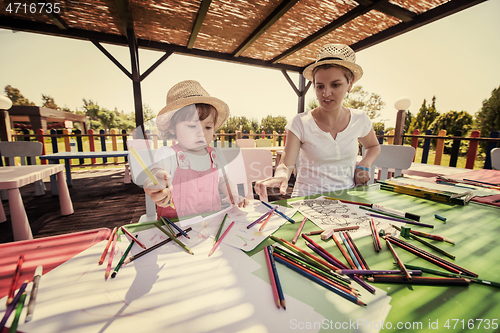 Image of mom and little daughter drawing a colorful pictures