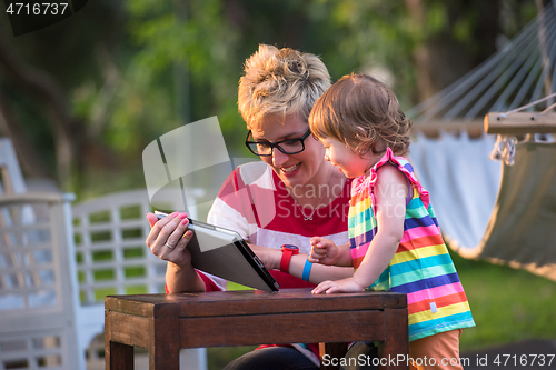 Image of mom and her little daughter using tablet computer