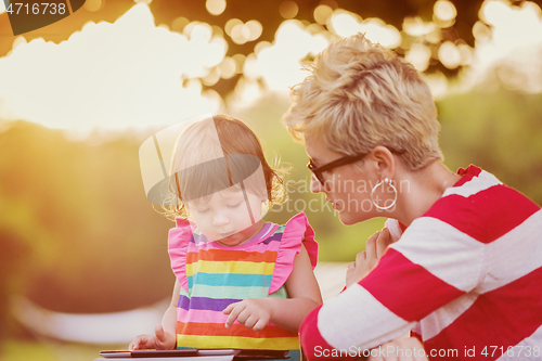 Image of mom and her little daughter using tablet computer